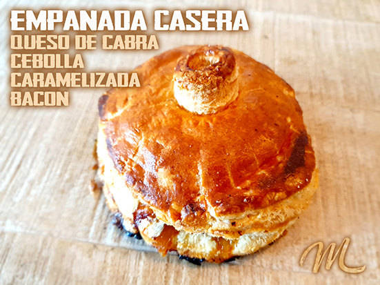 EMPANADA DE RULO DE CABRA, cebolla caramelizada y virutas de bacon